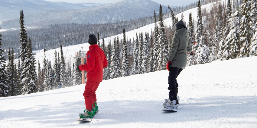 Person snowboarding down a snowy slope at Kongsberg Skisenter winter resort.