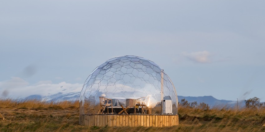 Glass igloo with snowy surroundings under a starry night sky at Kakslauttanen.