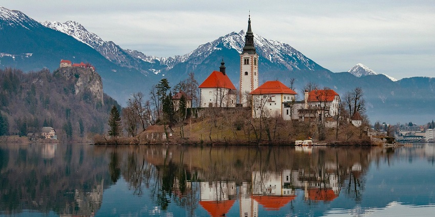 Church of the Assumption in Slovenia, perched on an island in Lake Bled, surrounded by water.