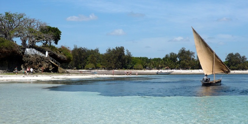 A boat floating on clear turquoise waters at Malindi Marine National Park under the sky.
