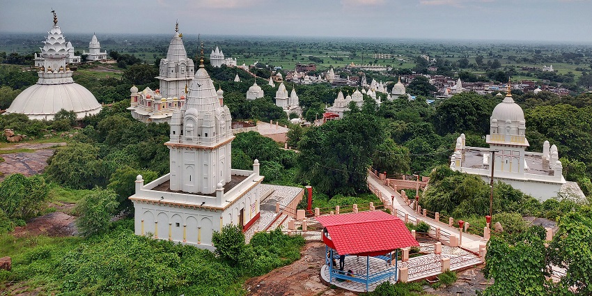 Sonagiri from above with multiple traditional white architectural temples and greenery.