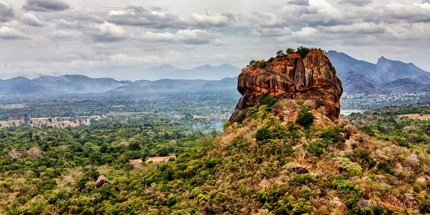Ancient rock fortress surrounded by lush forest at Sigiriya, Sri Lanka.

