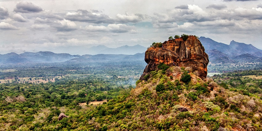 Sigiriya rock fortress in Sri Lanka surrounded by greenery, places to visit in February near India.
