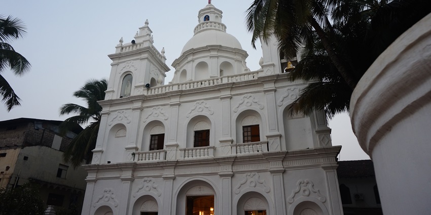 St. alex church in Calangute with a white architectural building of the church and a cross on top.