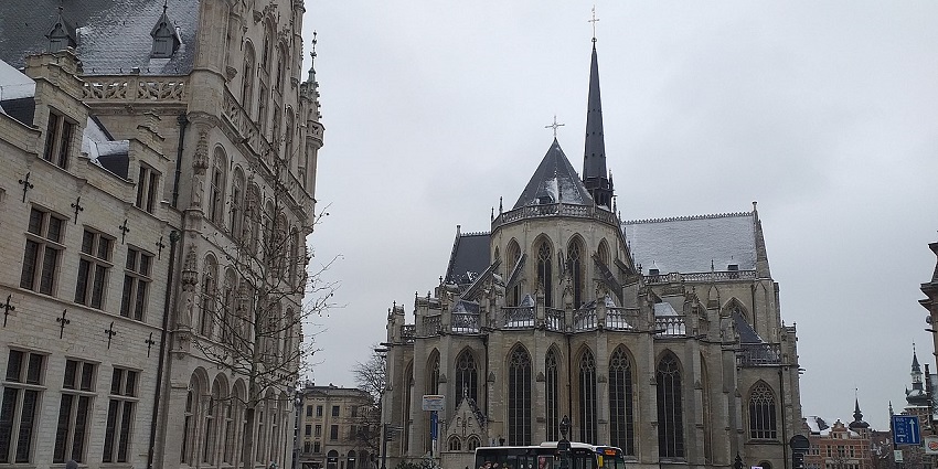 St. Peter’s Church in Leuven with a Gothic facade facing a road with people walking by.
