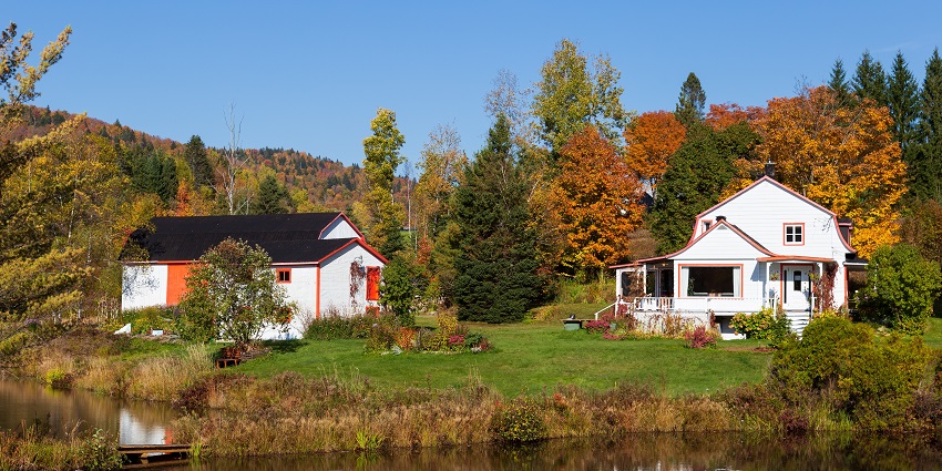 Houses in Stoneham-et-Tewkesbury surrounded by colorful autumn trees.