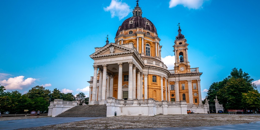 Superga Basilica with a traditional architectural building set against a scenic hillside backdrop.
