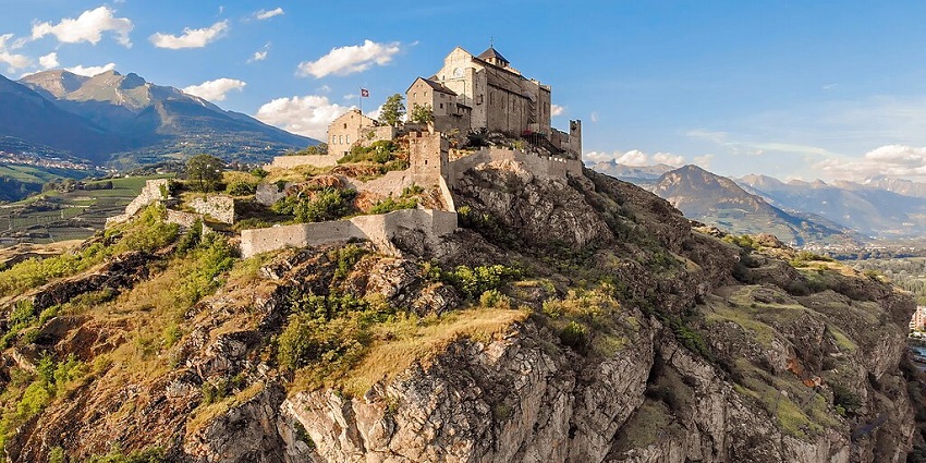 Hilltop Valère Castle in Sion, Switzerland, features stone walls and scenic mountain views.
