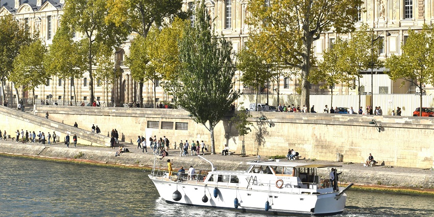 Boat cruising on the Río De La Plata with historic buildings in the background.