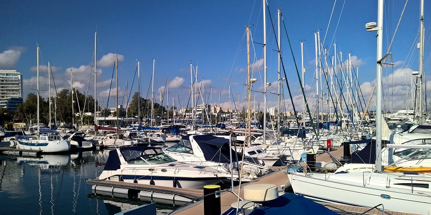 Boats and yachts docked at Larnaca Marina gently reflected in the calm blue water.