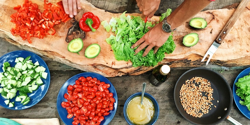 A kitchen setting with a chopping board and ingredients for a couple’s cooking class.