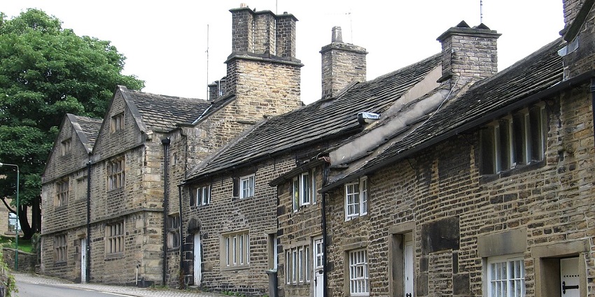 Street in old Glossop with old British architectural houses, entrance doors and windows.
