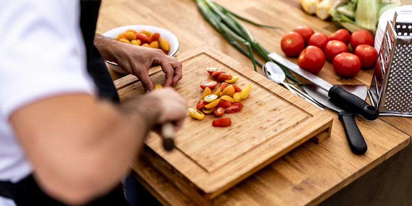 A person chopping ingredients during a traditional Lao cooking class in Luang Prabang.