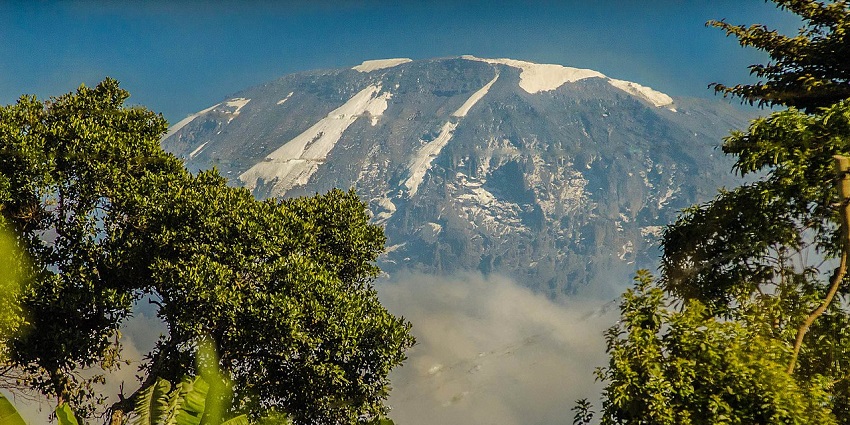 Mount Kilimanjaro rises above the town of Moshi in Tanzania, one of the top places to visit near Kenya.