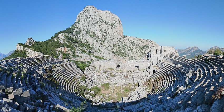 The ancient stone theatre at Termessos, nestled on a wooded hillside with mountains, one of the places to visit near Antalya.