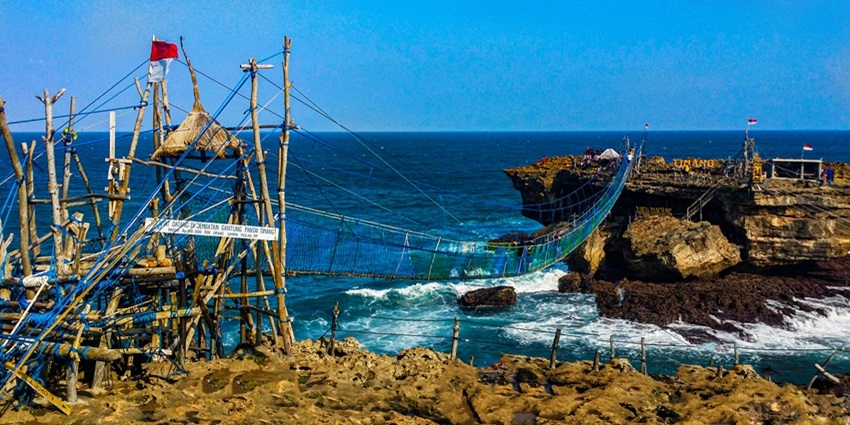 Dramatic Timang Beach with rugged cliffs and turquoise waters, one of the stunning places to visit near Yogyakarta.