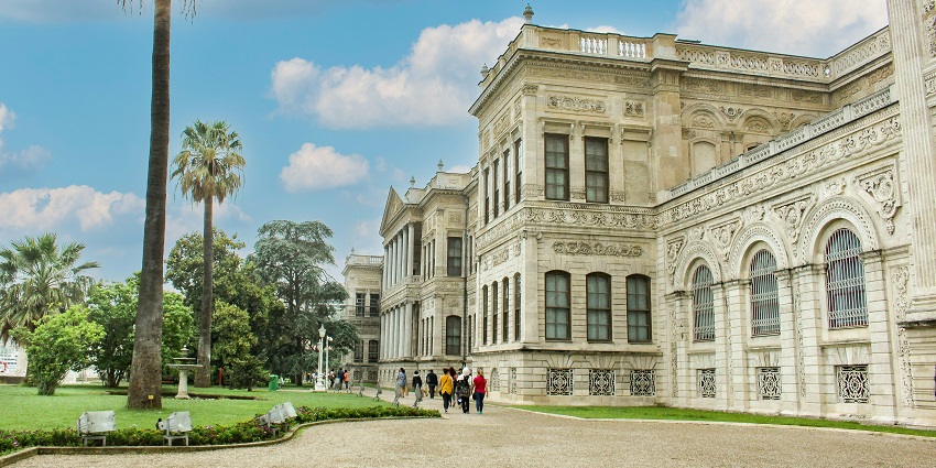 The Ras Gimb Palace Museum exterior with historic architecture and visitors standing.

