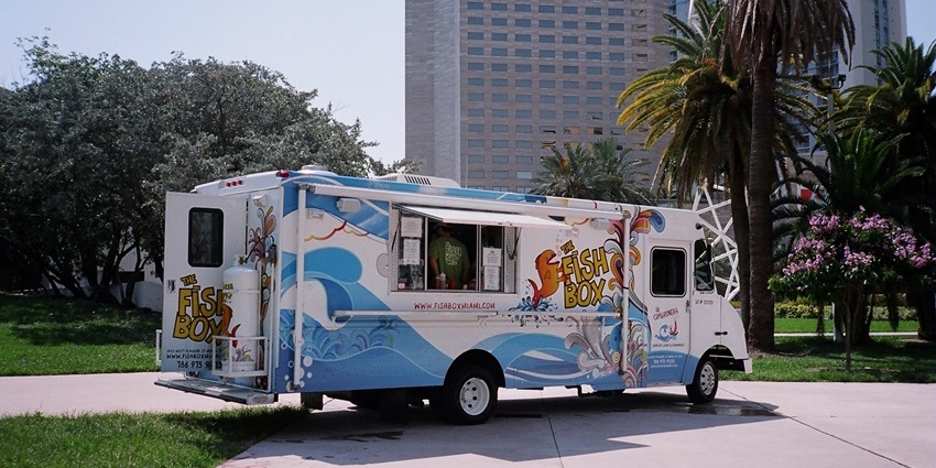 A food truck in Austin, Texas, with vibrant signage, outdoor seating, and customers nearby