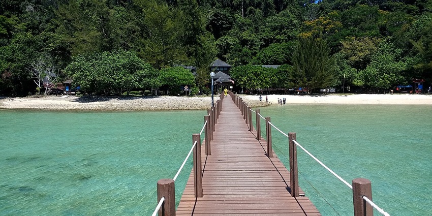 Beach and a wooden walkway in Gaya Island in Tunku Abdul Rahman Marine Park, one of the best places to visit near Kota Kinabalu.