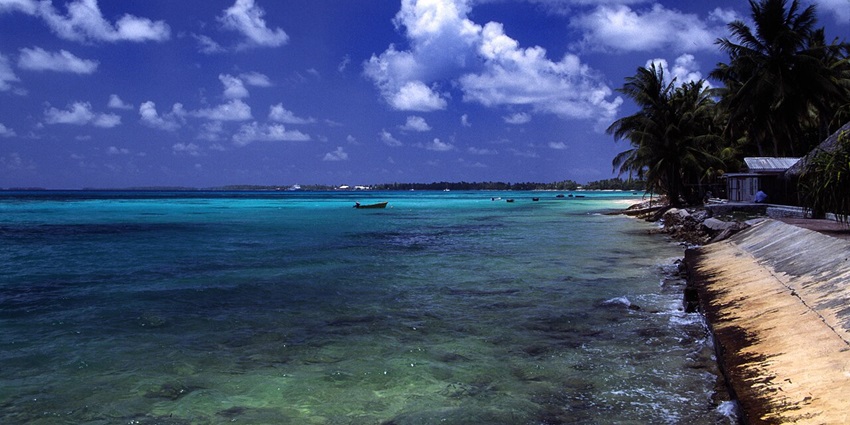 Peaceful island landscape of Tuvalu with clear blue waters and palm trees.