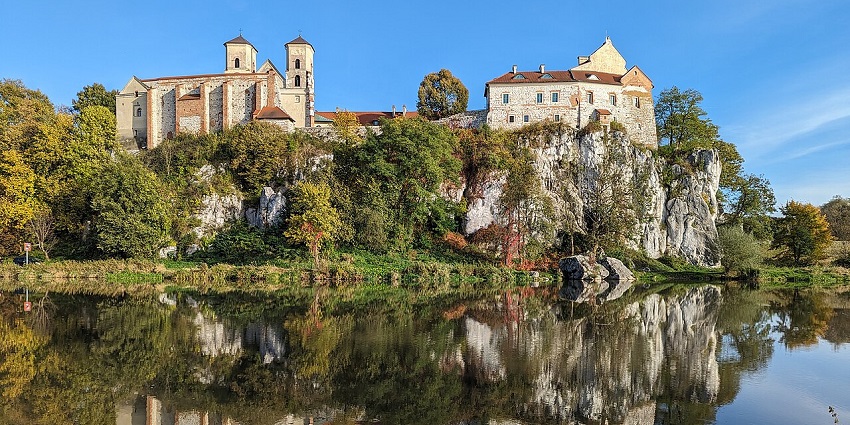 Historic hilltop monastery with red roofs and stone walls surrounded by greenery, one of the places to visit near Kraków.