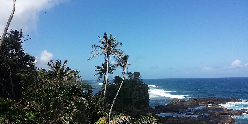 A breathtaking view of lush green valleys beside the beach in the heart of the Samoa Islands.
