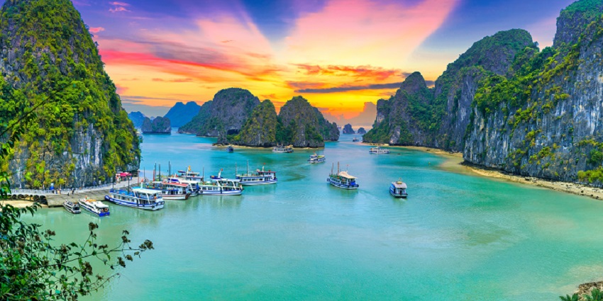 Sunset over Ha Long Bay with limestone cliffs, one of the breathtaking places to visit near Nepal.
