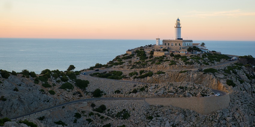 Scenic coastal lighthouse with rocky cliffs and panoramic views over the Mediterranean Sea.
