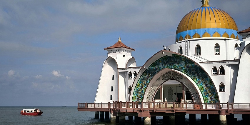 Al-Hussain Floating Mosque in Kuala Perlis during daytime with calm waters around.