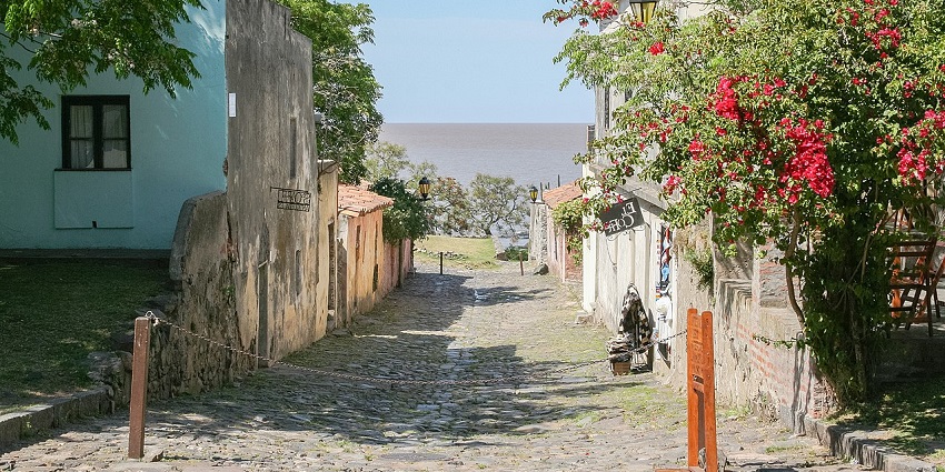 Historic quarter of Colonia del Sacramento with old architectural buildings and green trees.