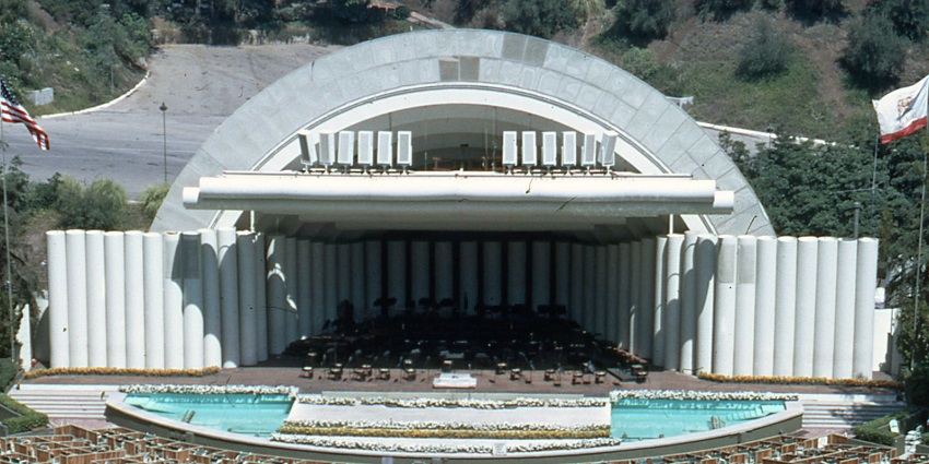 Hollywood Bowl outdoor amphitheatre with empty stage, visible seating in front of a hill.