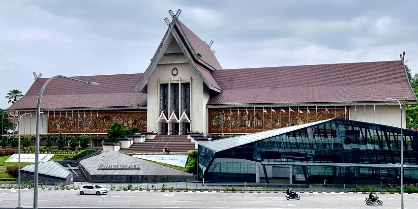 Colonial-era Kota Kayang Museum surrounded by greenery under clear sky.