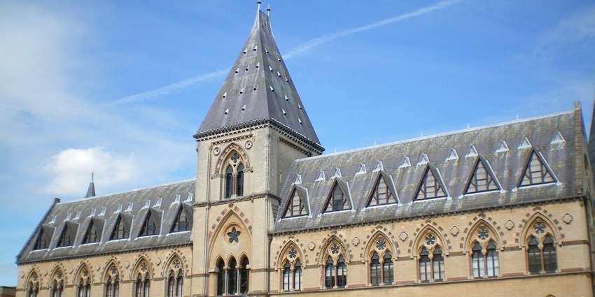 Front view of Oliver Cromwell’s Museum, a historic brick building with large windows.