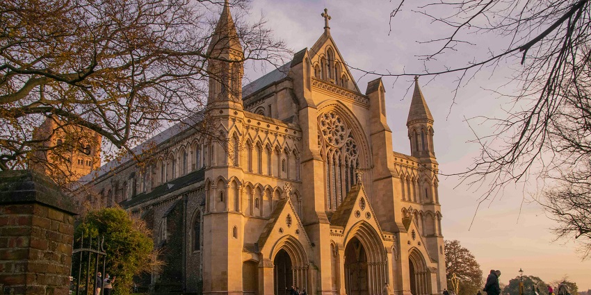 Exterior view of the historic Church of St Edmunds with stone walls and a tall tower.
