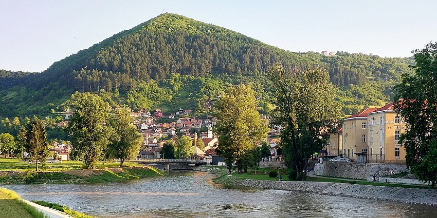 A peaceful river flows through Visoko with surrounding green hills and natural landscape.