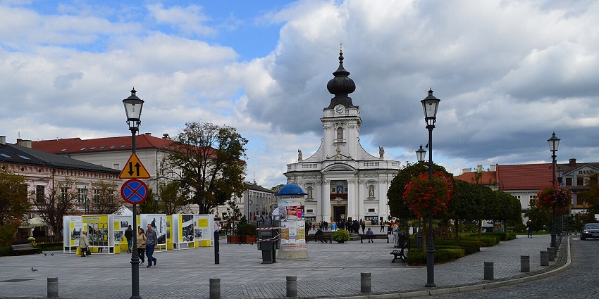 Charming town square with a white church, vintage lampposts, flower baskets, and casual strollers.