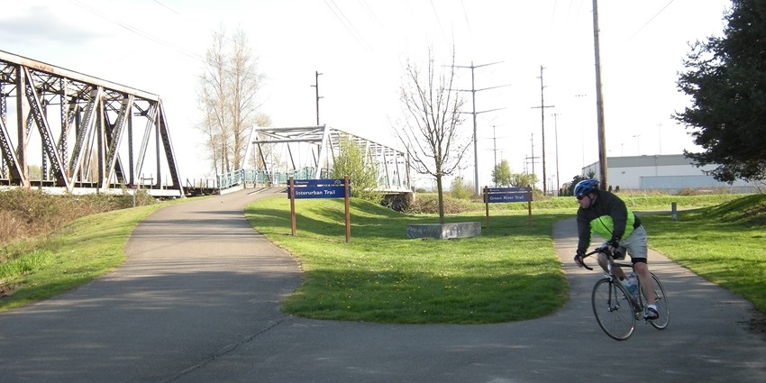 Cyclist at the grassy junction of Green River and Interurban trails , one of the best things to see in Lynnwood.