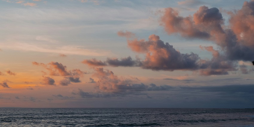 Enjoy the peaceful beachfront with colorful skies, one of the perfect things to do in Kuta Bali at night.