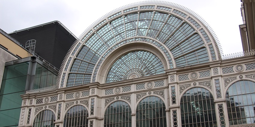 Close-up view of the Royal Opera House in London, with its columns and arched glass front.