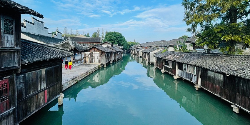 Wuzhen in China with a small clear water body of canal and traditional houses on both sides.