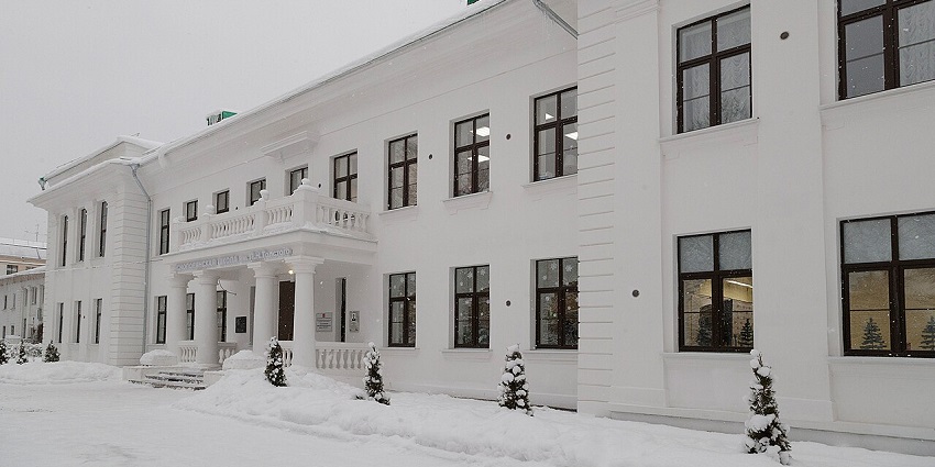 White neoclassical building with columns and a balcony, surrounded by snow, amongst the top places to visit near Moscow.