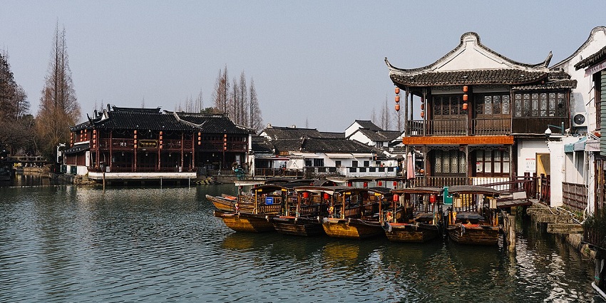 Zhujiajiao water town with multiple roofed boats and traditional Chinese buildings, one of the best places to visit near Shanghai.