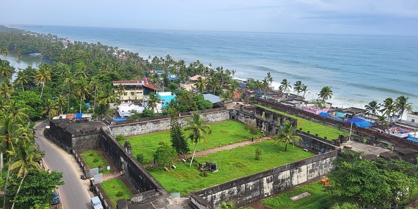 Aerial view of Anchuthengu Fort showing old stone buildings and surrounding greenery.
