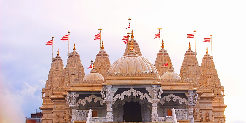 Wide view of Radha Rani Temple in Barsana with stairs leading up and a flag on top.