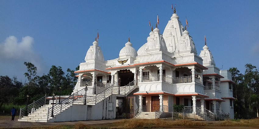 The white traditional Bawkhaleshwar Temple with flags, one of the places to visit near Ghansoli.
