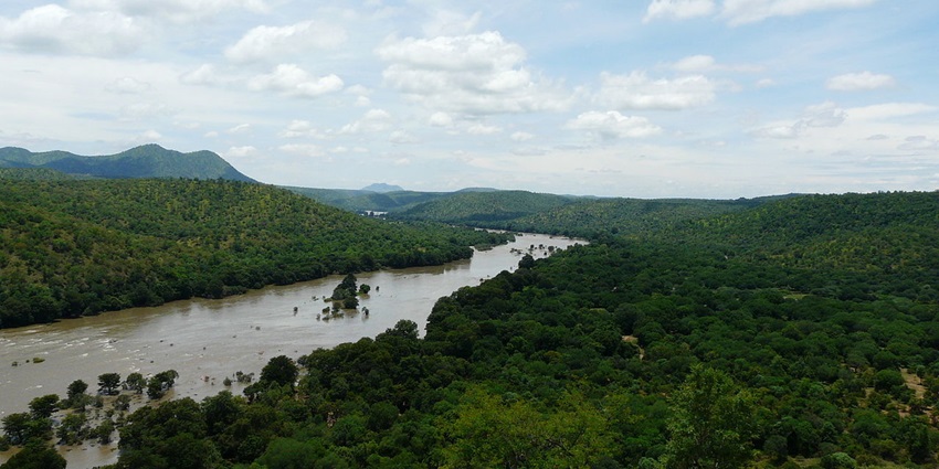 Bheemeshwari River flowing through green surroundings with calm waters and forested banks.
