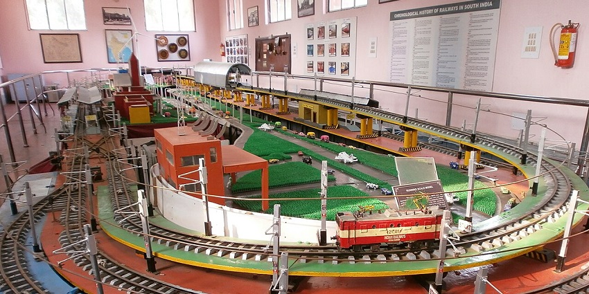 Inside Chennai Rail Museum with models of trains, railway tracks, railway stations and signboards.
