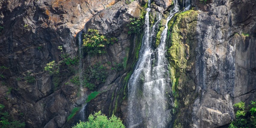 Chorla Ghat waterfall surrounded by dense forest and mist, a tranquil natural spot.
