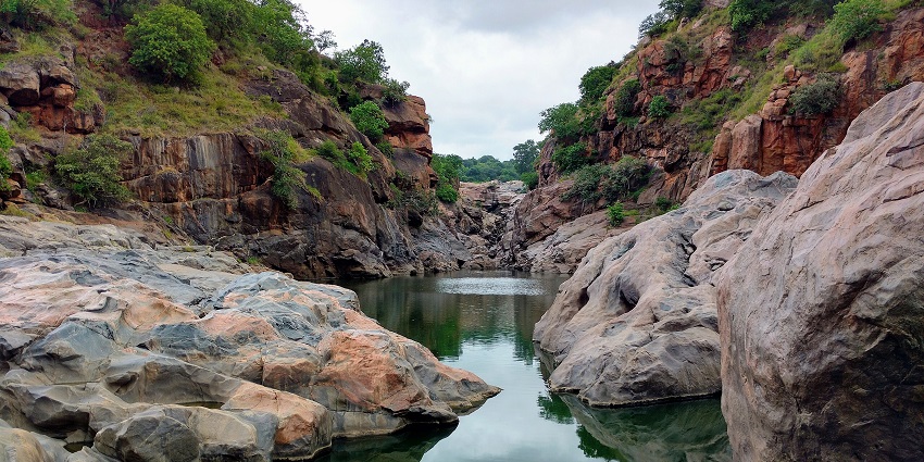 A view of still waters surrounded by rocky structures at Chunchi Falls near Bangalore.