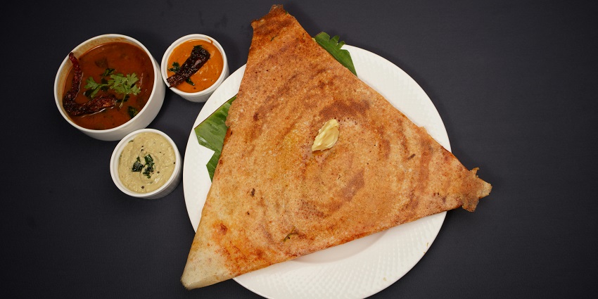 Freshly made neer dosa served on a plate with chutney and traditional side dishes.